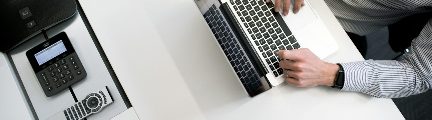 person using laptop on white wooden table