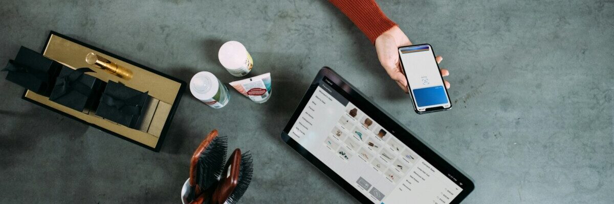 person holding smartphone beside tablet computer