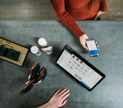 person holding smartphone beside tablet computer