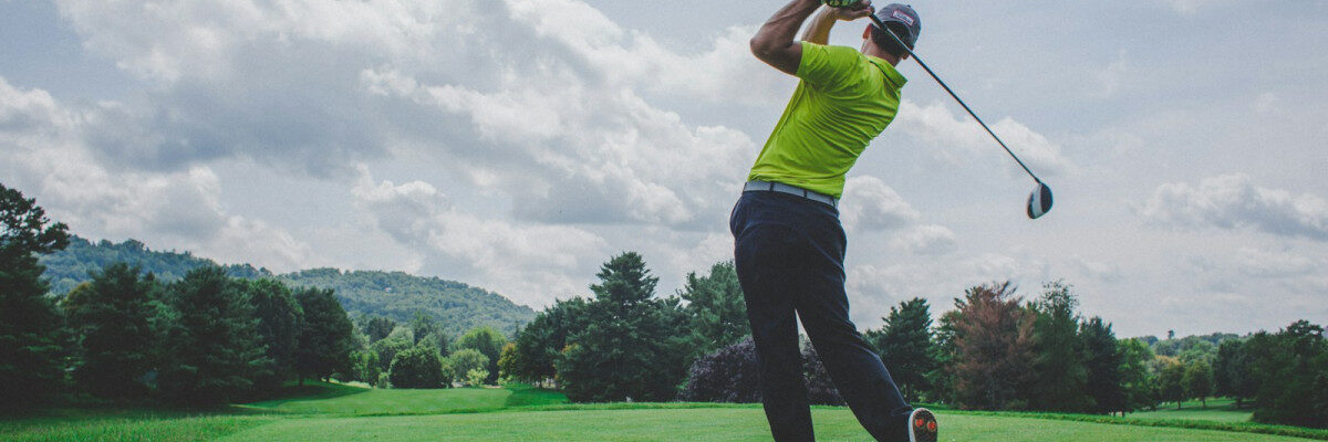 photo of man swinging golf driver