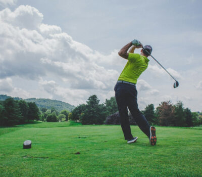 photo of man swinging golf driver