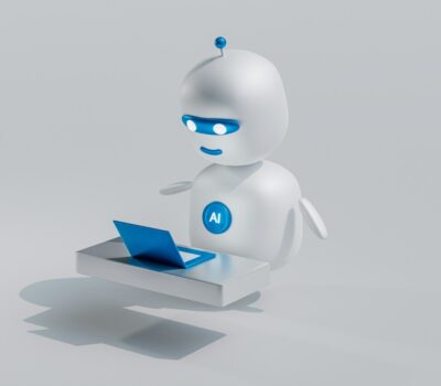 a white robot with blue eyes and a laptop