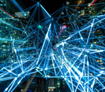 Dynamic urban scene showcasing interconnected light trails representing digital communication networks.