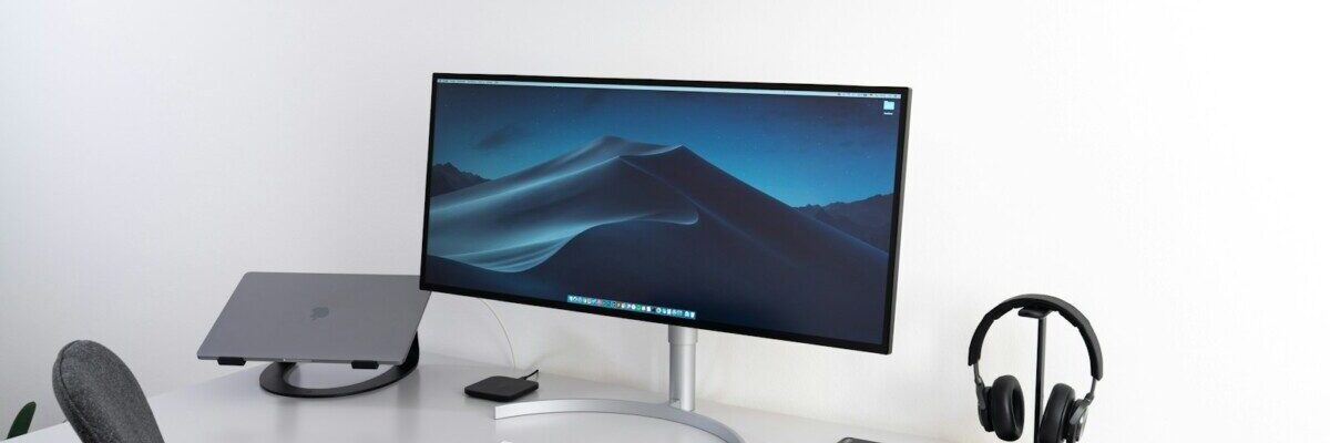 black flat widescreen computer monitor with with Apple Magic Keyboard and mouse on desk