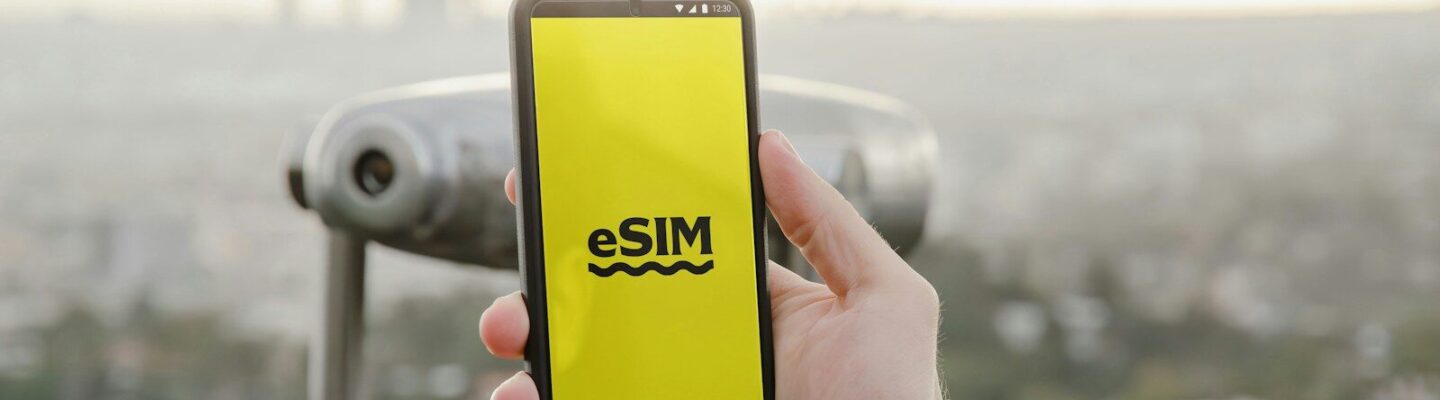 a person holding up a cell phone with a logo on it