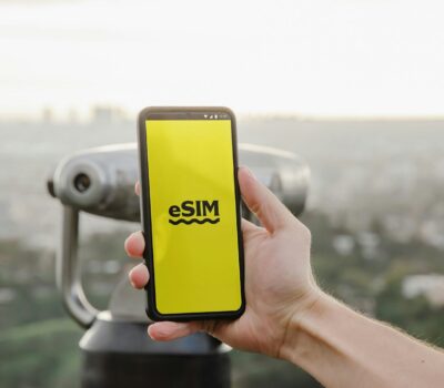 a person holding up a cell phone with a logo on it