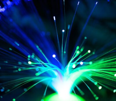 Close-up of illuminated fiber optic lights in blue and green colors, showcasing modern technology.
