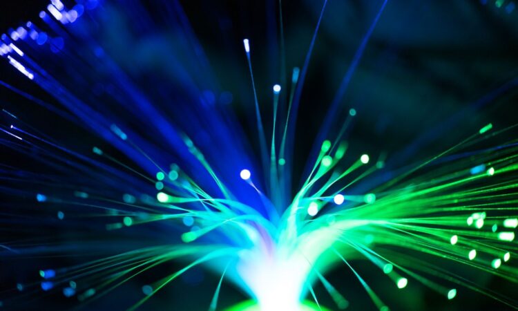 Close-up of illuminated fiber optic lights in blue and green colors, showcasing modern technology.