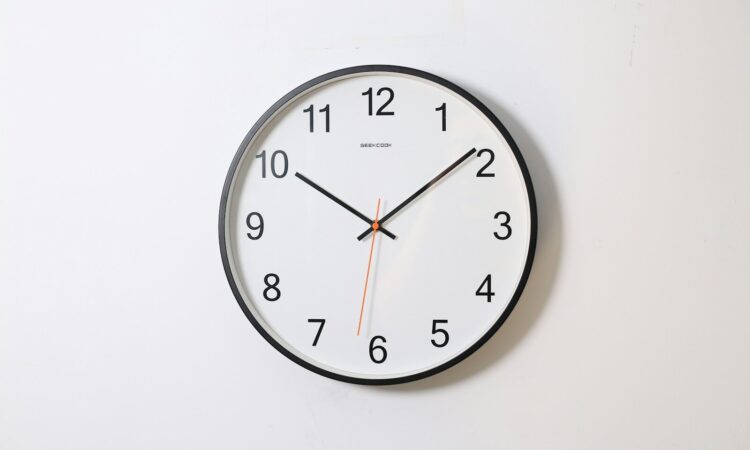 round analog wall clock pointing at 10:09