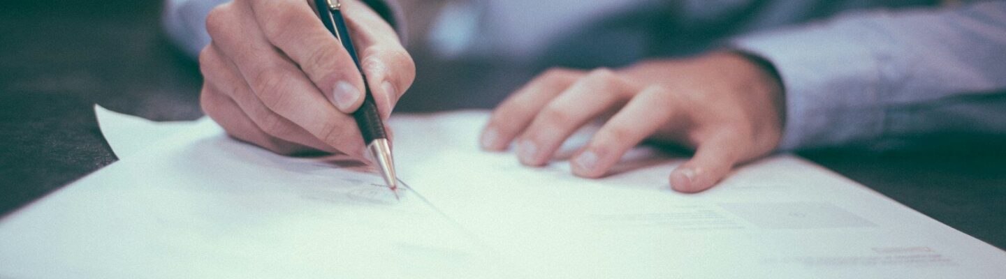 man writing on paper