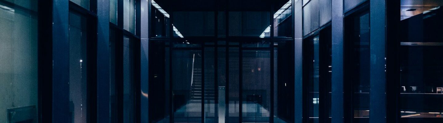 a long hallway with glass doors leading to another room