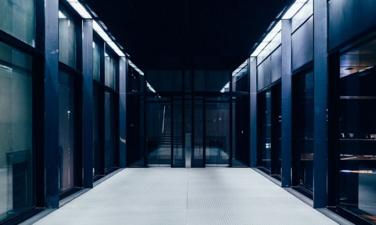 a long hallway with glass doors leading to another room